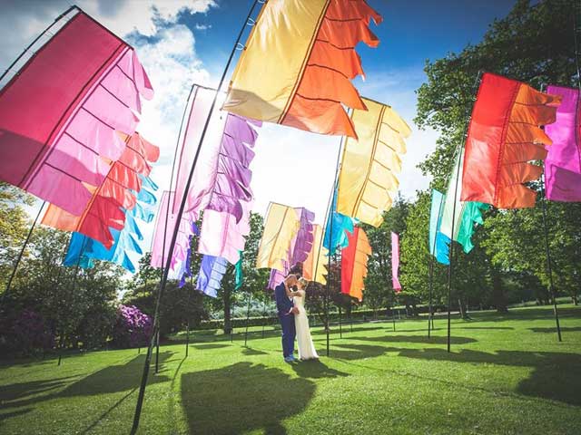 A field of flags around a bride and groom.