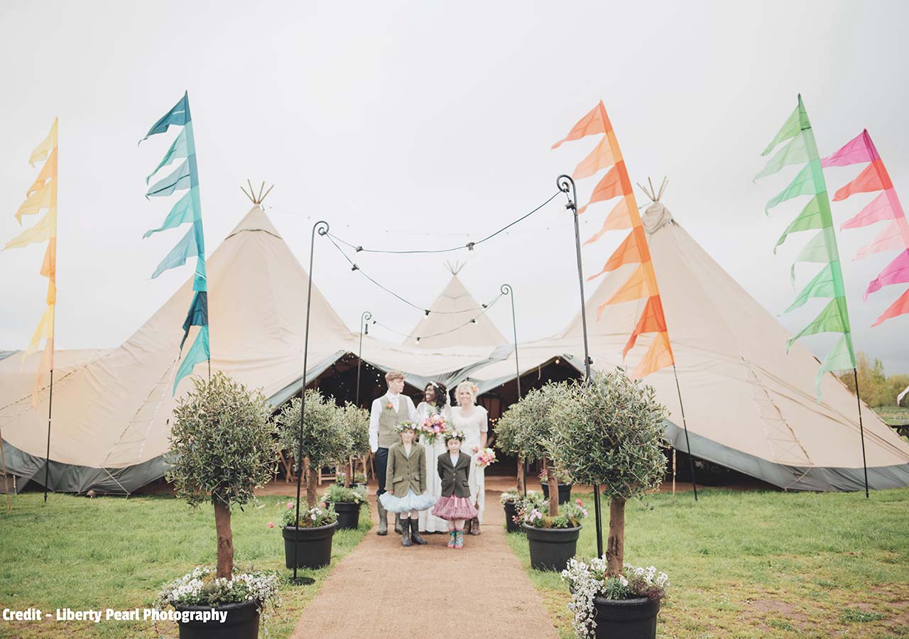 festival style wedding with flags and tepee reception tent