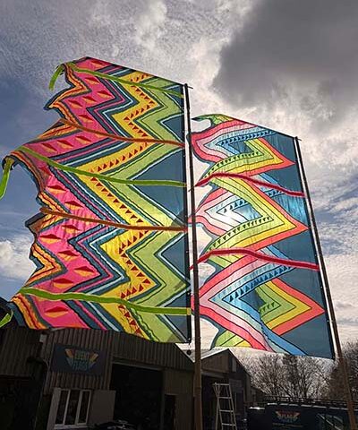 neon mexican flag aztec design pattern glowing against daylight sky